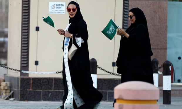 Saudi women hold national flags during Saudi National Day in Riyadh, Saudi Arabia Friday.
