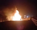A fire burns on a damaged bridge in the aftermath of a strike in Bandar Khamir in Iran’s Hormozgan province on Thursday