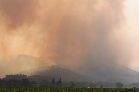 Smoke above countryside and a few houses
