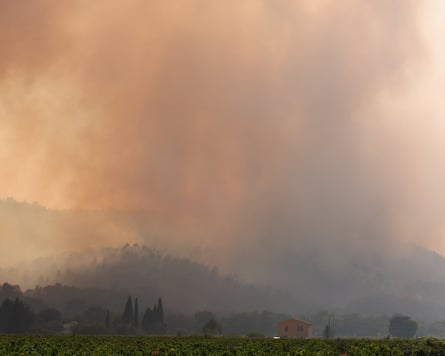 Smoke above countryside and a few houses