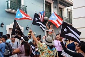Demonstrators chant and wave Puerto Rican flags during the fourth day of protests calling for the resignation of Governor Ricardo Rosselló in in San Juan, Puerto Rico
