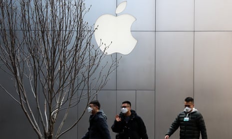 Beijingers with face masks pass an Apple store.