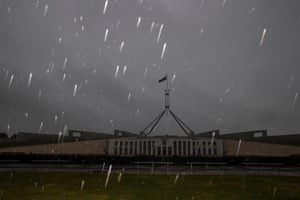 The flash from a camera highlights raindrops during another deluge over Parliament House in early August.