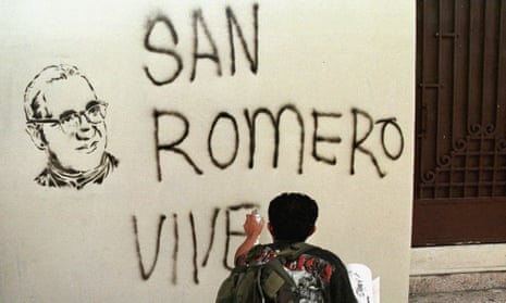 A Catholic faithful paints a sign reading, “San Romero Lives” on 24 March 1999, during a mass to commemorate the 19th anniversary of the killing of Oscar Romero. 