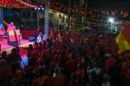 A man speaks on stage to a crowd of people.