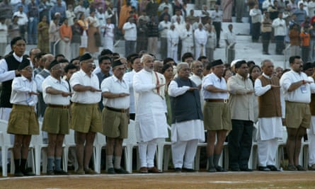 Narendra Modi stands among members of the Hindu nationalist RSS and performs a salute
