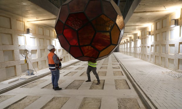 Labourers work with one of the Yvelle Gabriel-designed light fixtures as the cemetery’s opening date approaches.
