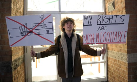 Max Nibert, a Huntington high school senior, holds signs reading ‘My rights are non-negotiable.’