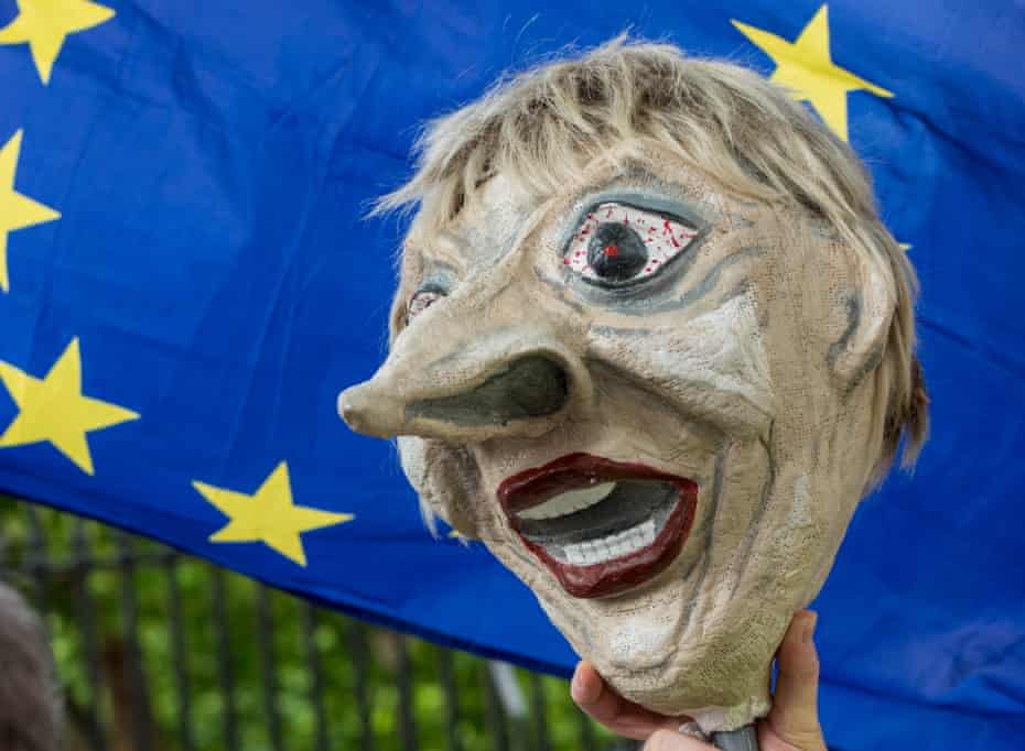 A puppet of Theresa May in front of an EU flag.
