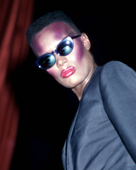Grace Jones with very sharp hair, makeup and sunglasses