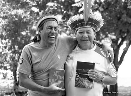 Two men in headdresses holding books