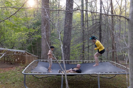 A family of three playing ona trampoline