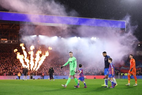 Crystal Palace keeper Dean Henderson leads his teammates out as pyrotechnics go off at Selhurst Park.