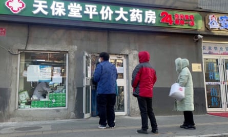 People queue outside a pharmacy in Beijing