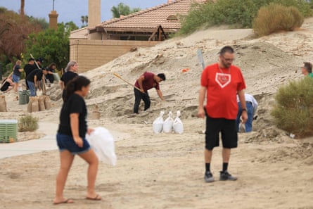 Residents shovel and fill sandbags from the desert along the side of the road in Indio, California, on Saturday, as the path of Tropical Storm Hilary heads north towards southern California.