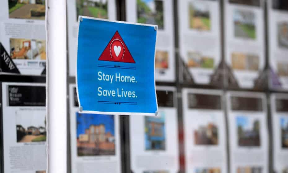 A stay home, save lives sign in an estate agents window