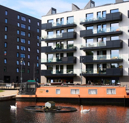 Flats overlooking a marina with a narrow boat and swans in the foreground