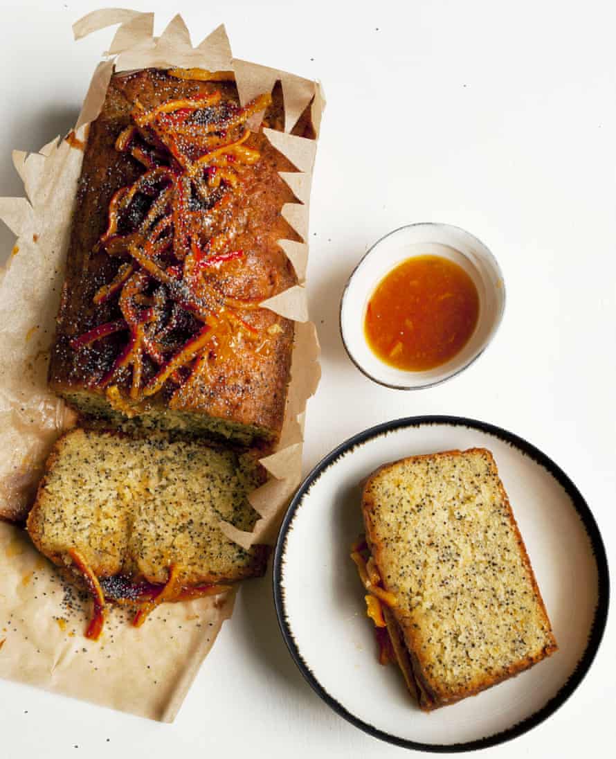 Nigel Slater’s orange and poppy seed cake in opened parchment paper, with a slice on a plate and a dish of orange confit
