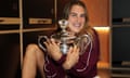 Aryna Sabalenka celebrates with the trophy in the locker room after her win over Zheng Qinwen