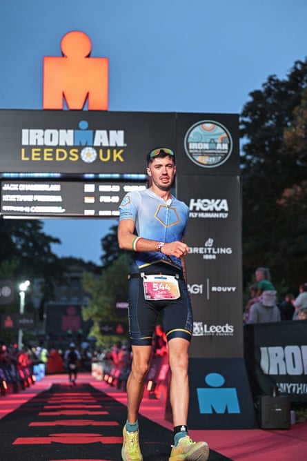 Jack Chamberlain crosses the finish line at Ironman Leeds, wearing his race number 544, with the event branding visible behind him.