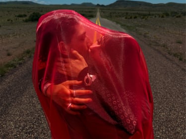 Think Love, 2025 two lovers kiss beheath a gauzy red fabric