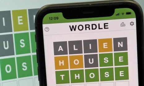 A phone with a solved Wordle game displayed on the screen.