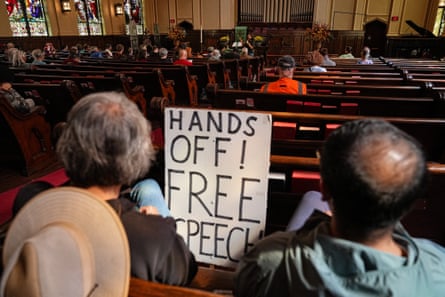 Church attendees at an election observer training, one holding a âÂÂHands Off! Free Speech!â sign