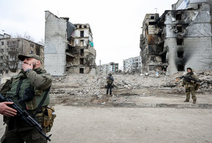 Servicemen patrol next to the ruins of buildings destroyed by Russian shelling in Borodyanka, Kyiv.