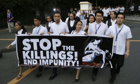 seminarians and nuns carry slogans and a mock coffin during a rally in Manila, Philippines, against drug-related killings and martial law