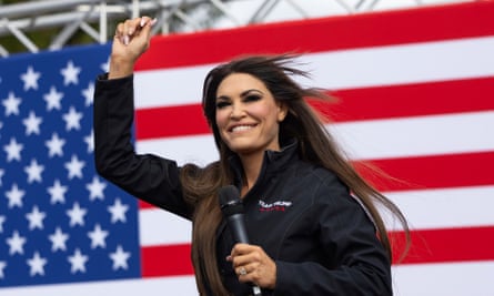 Kimberly Guilfoyle waving in front of an American flag