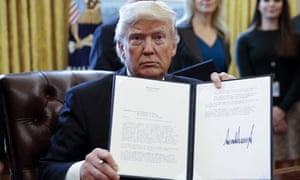Donald Trump displays one of five executive orders he signed related to the oil pipeline industry in the oval office of the White House January 24, 2017 in Washington, DC.