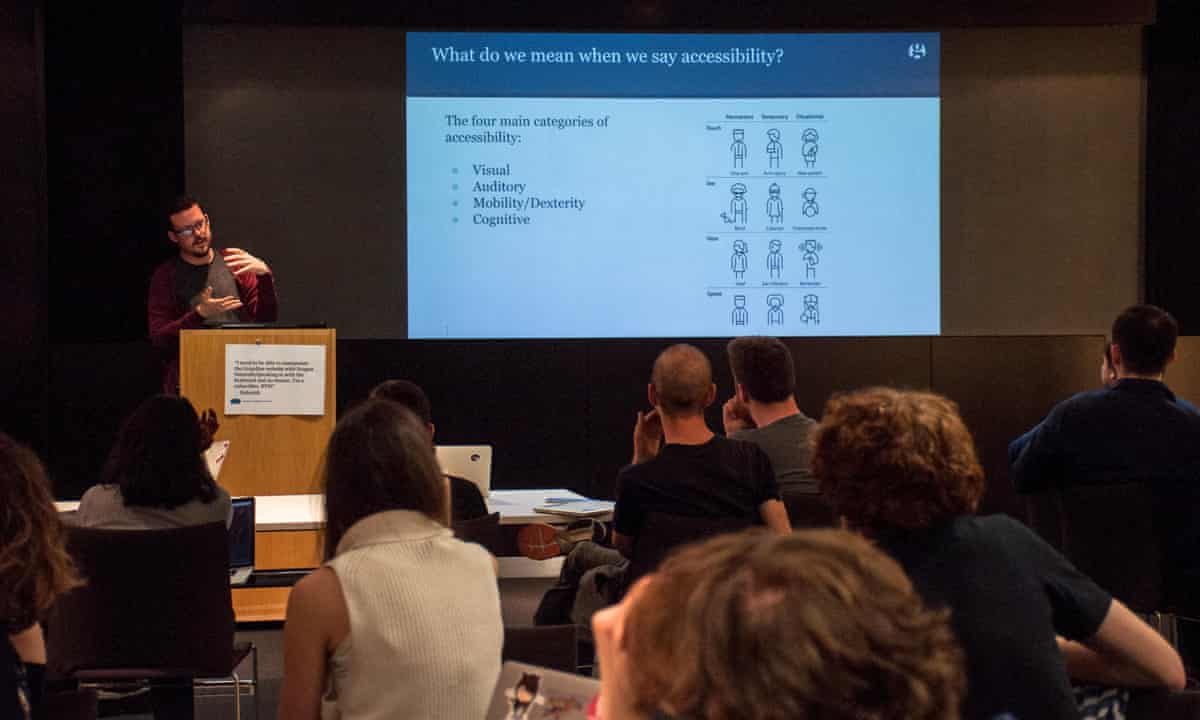 A member of the Guardian Accessibility Working group stands at a lectern, presenting a slide deck. The screen shows a diagram demonstrating the types of Accessibility requirements