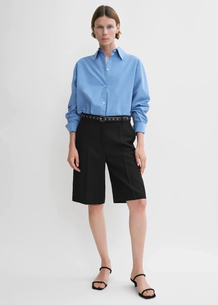 Model wearing black Bermuda shorts and blue shirt