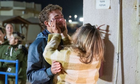 A woman puts her hands round the face of a tearful Itay Regev.