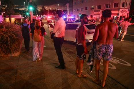 People stand on a street after the shooting.