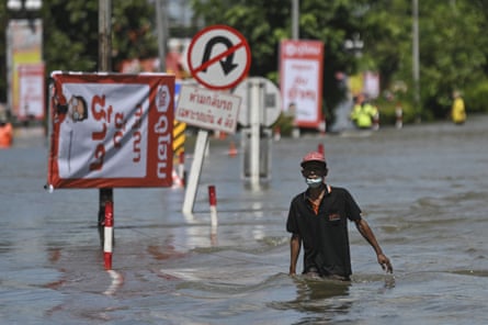 A resident wades through flood water in Ubon Ratchathani province, north-east Thailand, on 5 October