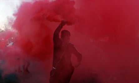 A demonstrator holds a flare during a protest against Uber in Paris.