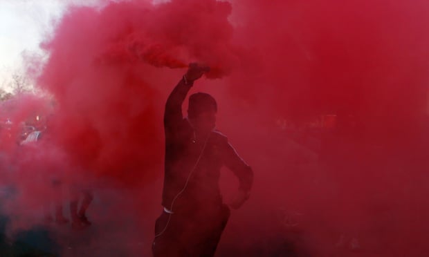 A demonstrator holds a flare during a protest against Uber in Paris.