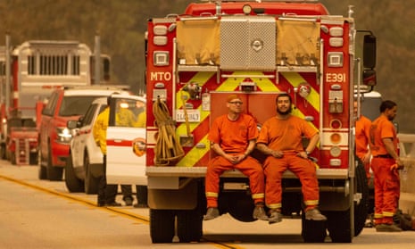 Inmate firefighters sit on the back of a fire truck while taking a break from the Bear fire, in unincorporated Butte county, in Oroville, California.