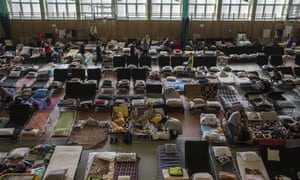 People who fled the war in Ukraine rest inside an indoor sports stadium being used as a refugee center, in the village of Medyka, a border crossing between Poland and Ukraine.