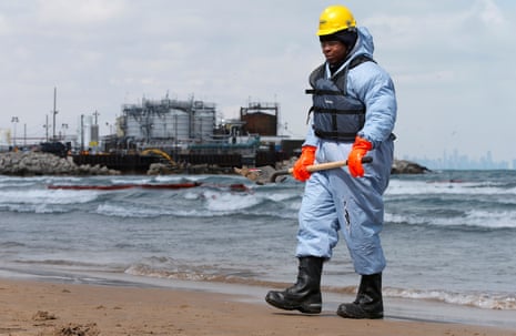 An oil-spill response contractor cleans up crude oil on a beach after a BP oil spill on Lake Michigan in Whiting, Indiana, US.