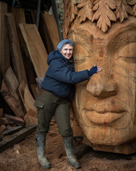 Sarah Eberle stands next to the head of the sculpture created by Chris Wood for her Chelsea garden.