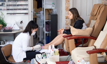 A technician works on a customer’s feet at a nail parlour in Sydney on Monday on the first day beauty salons were allowed to open again in NSW.