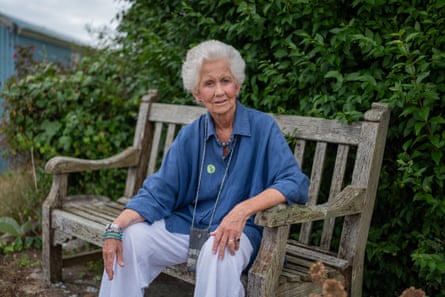 Deborah in a light blue shirt sat on a bench outside
