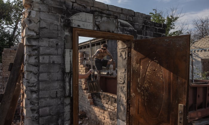 A young volunteer from the ‘Repair Together’ initiative cleans rubble from a house that was destroyed during the Russian invasion, at Ivanivka village, Chernihiv region on 30 July 2022 (issued 04 August 2022). EPA/ROMAN PILIPEY