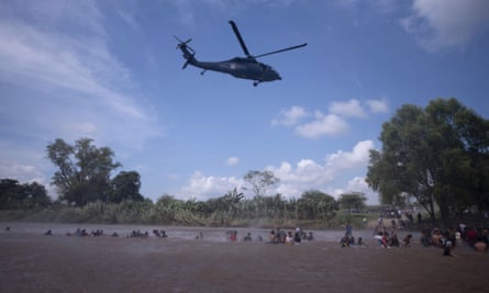 A Mexican federal police helicopter flies close to the Suchiate river that connects Mexico and Guatemala, in order to create a downwash force to discourage a new group of Central American migrants wading across the river on Monday.