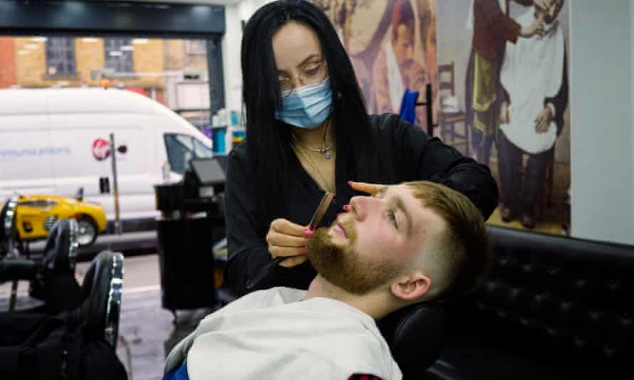 JP Lombard removes his mask to have his beard cut at Barber Line Turkish barbers in Camden, but otherwise says he is happy to wear one.