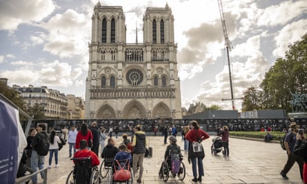 People outside look up at the towers of Notre Dame