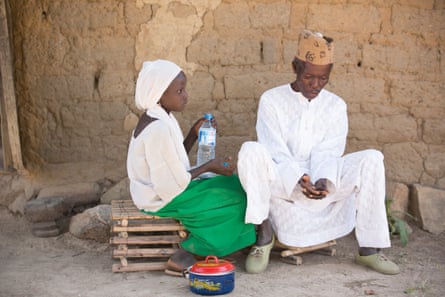 Seven-year-old Dorcas and her grandfather Simon successful Kudaru, successful bluish Nigeria, dressed successful accepted clothing.