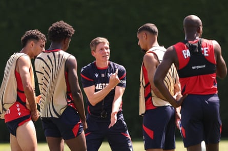 Oliver Glasner speaks to some of his players in training